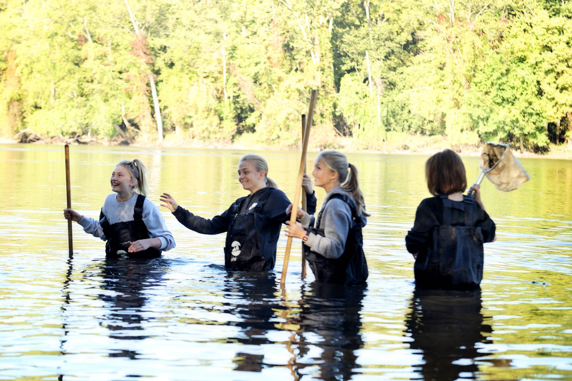 Four students in waders with nets in a river completing a Groundswell Stewardship Initiative Project